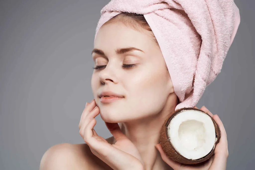 aceite de coco | Clínica de Dermatología Robótica Mujer aplicando aceite de coco para la cara frente al espejo- clinica de dermatología robótica