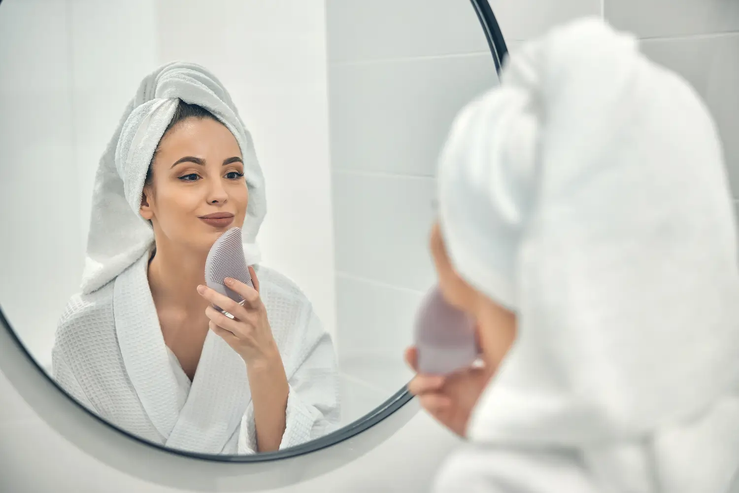 Dermatologia | Clínica de Dermatología Robótica Mujer realizando su rutina de skincare frente al espejo - clinica de dermatologia robótica